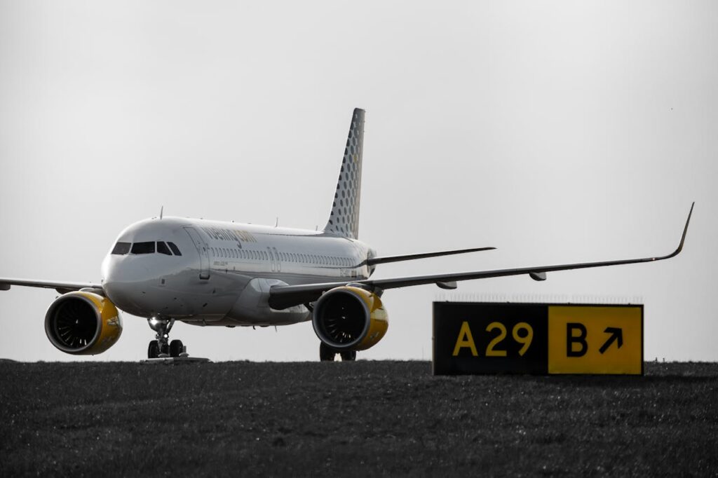 Passenger airplane taxiing at Schiphol Airport with A29 runway sign in foreground.