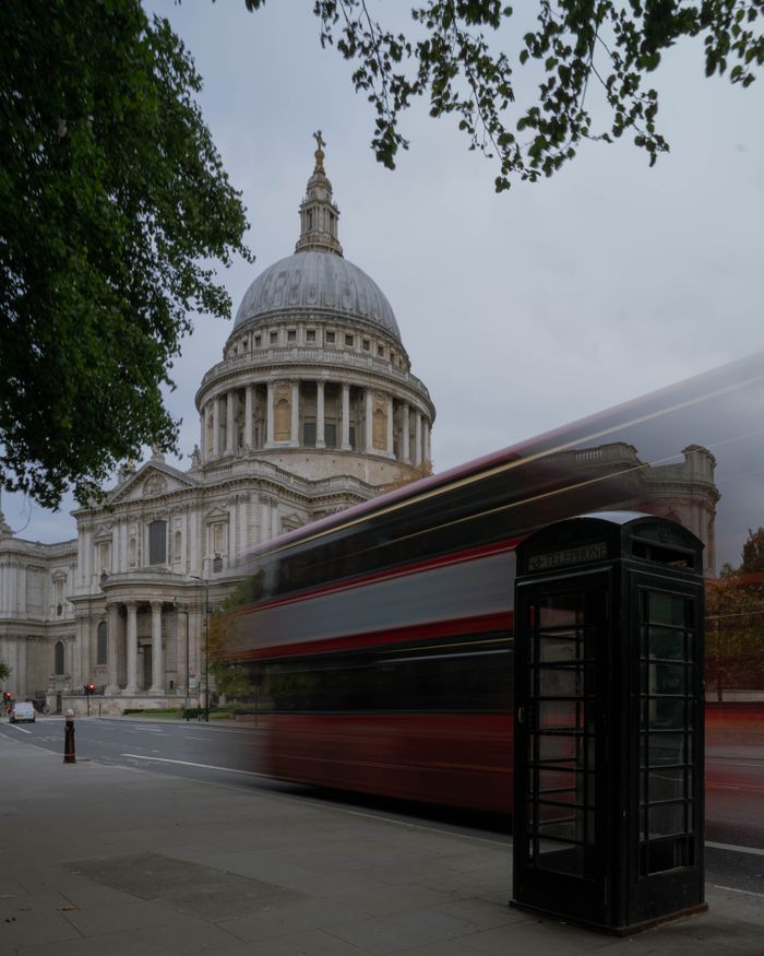Iconic St. Paul's Cathedral and classic red bus captured in busy London street view.