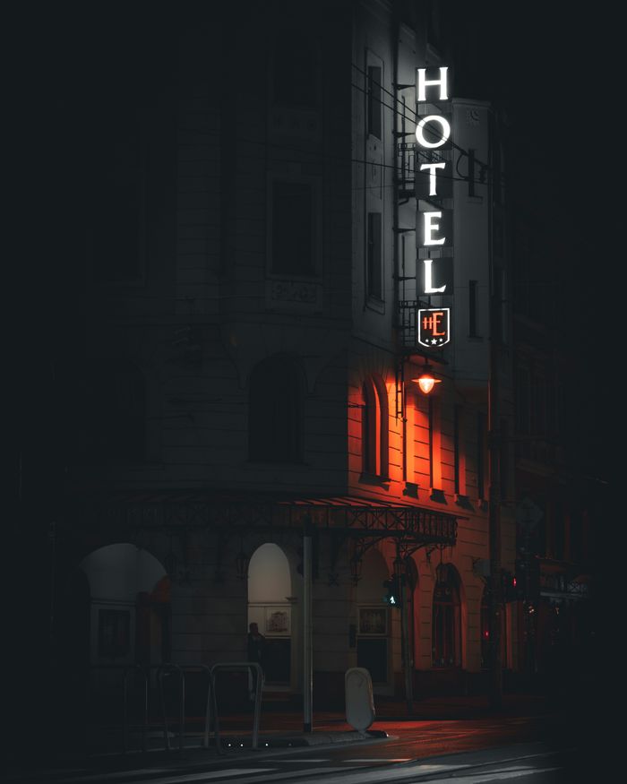 Gothic hotel facade with neon sign glowing at night in Wrocław, Poland.