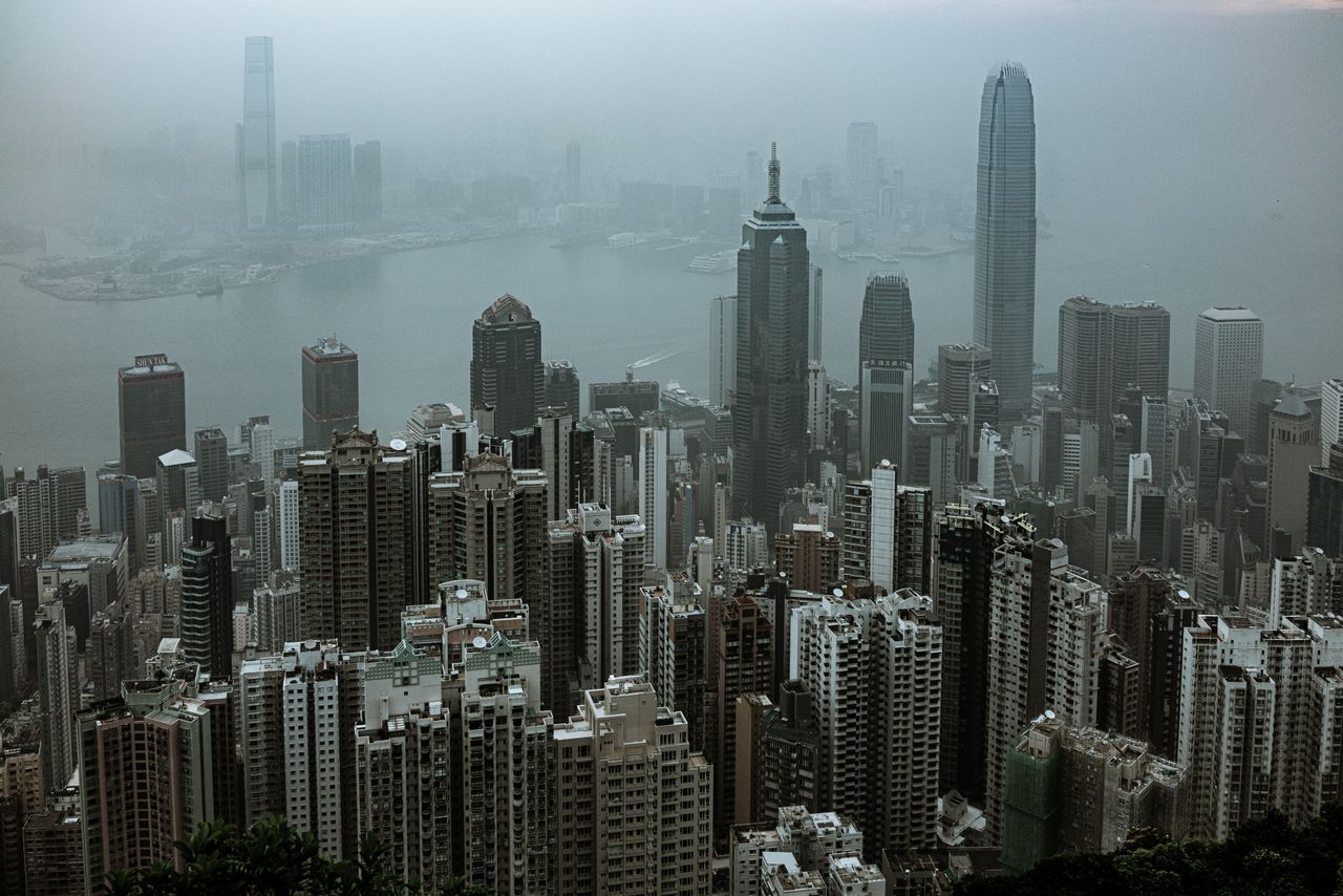 About Aerial view of Hong Kong's iconic skyscrapers shrouded in fog over Victoria Harbour.